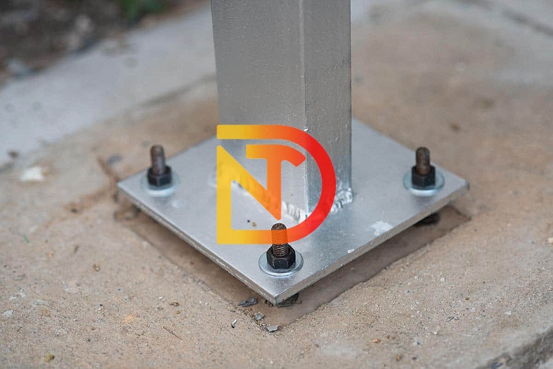 Bản mã chân cột đóng vai trò truyền trực tiếp tải trọng nén, uốn, hoặc kéo từ cột xuống móng.